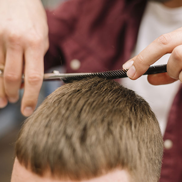 Corte de pelo con tijeras Corte de pelo con tijeras y peine en peluquería